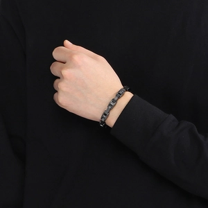 Close-up of men's black stainless steel watchband link bracelet on wrist with industrial design