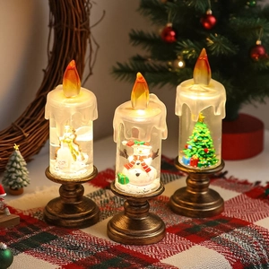Détail de lanternes bougies LED de Noël avec figurines d'ange, de bonhomme de neige et de sapin