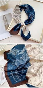 Détail d'un foulard en soie avec motif de plan bleu marine et beige sur un bureau