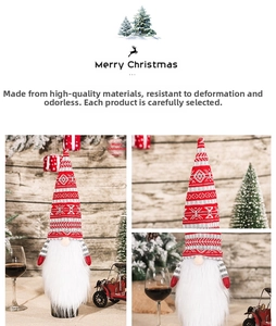 Detail of Christmas gnome wine bottle cover with red striped hat and soft white faux fur beard