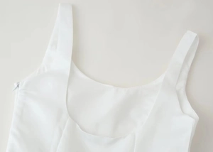 Détail d'une robe blanche à col en U avec doubles bretelles et fermeture éclair invisible