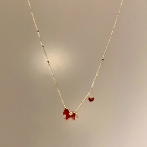 Gold-plated necklace with red enamel Scottie dog pendant and heart charm on a chain