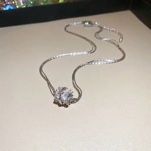Macro shot of silver multilayer pendant necklace with zircon rhinestones on beige stand