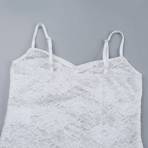 Dettaglio di canotta in pizzo bianco con scollo a V e intricati motivi floreali