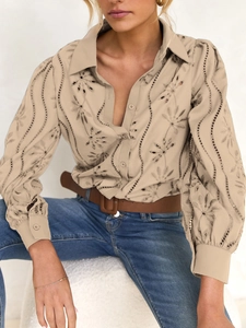 Detailed view of beige button-up shirt featuring delicate floral embroidery and eyelet design