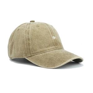 Close-up of white circular logo embroidery on a vintage washed khaki baseball cap