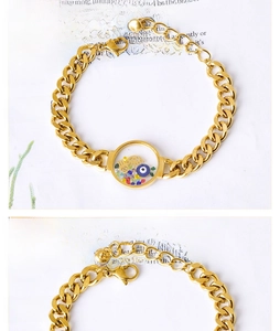 Detailed macro view of gold Cuban link bracelet with colorful evil eye pendant charms