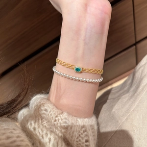 Detail of French vintage gold mesh bracelet with green stone and pearl bead bracelet