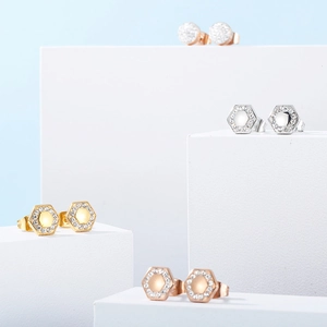 Makro-Anzeige von geometrischen und runden Diamantohrringen in Gold, Silber und Roségold