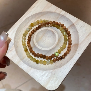 Vue détaillée de bracelets en perles turquoise sur un plateau en bois épuré