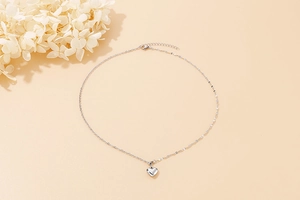 Detailed view of a silver heart-shaped pendant on a minimalist thin chain