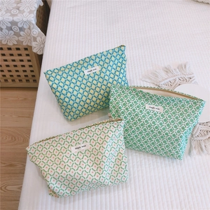 Close-up of three floral cotton cosmetic bags with zippers and simple wish labels