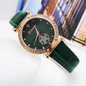 Macro detail of quartz watch featuring crystal bezel, green dial, and star cut-out design