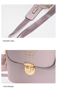Detail view of mauve textured leather shoulder strap and front design with golden rivets