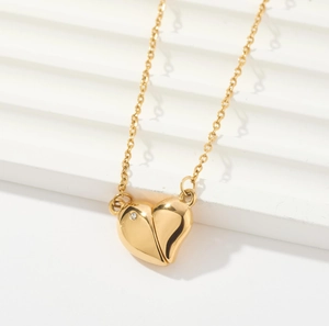 Close-up of interlocking heart pendants in gold finish with crystal inlay and fine chain