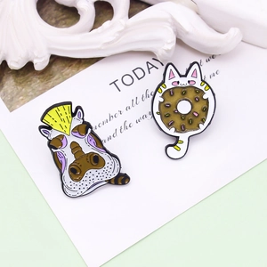 Cartoon hippo with mohawk and cat with donut enamel pins on a white decorative card