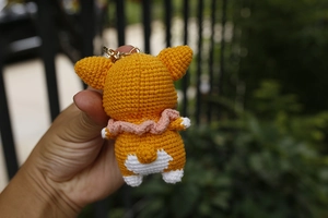 Detailed back view of a hand-knitted Corgi dog charm with a gold metal keyring attachment