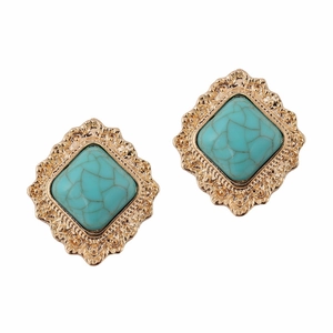 Close-up of vintage gold diamond earrings with turquoise stones in a geometric rhombus design