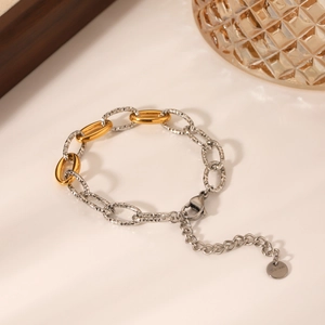 Two-tone mixed metal chain bracelet with gold and textured silver links in a minimalist style