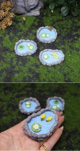 Macro shot of miniature garden ponds with tiny resin ducks and frogs for succulent decor