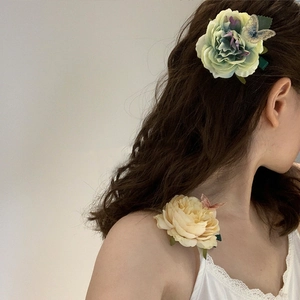 Detail of floral hair claw clips with butterflies on green and yellow fabric flowers
