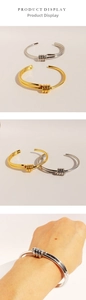 Detail view of gold and silver knot bangles showing double-layer spiral design and fit