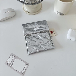 Close-up of silver quilted heart-pattern pouch with snap button for small essentials
