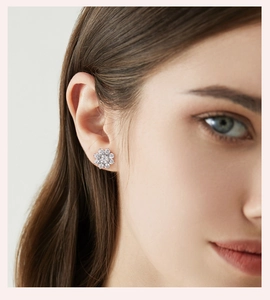 Close-up of model wearing silver flower stud earrings with sparkling pave crystals