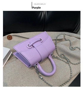 Detail of purple mini crossbody bag with litchi grain texture and silver beaded chain
