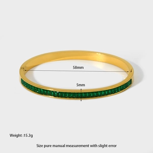 Detail of 18k gold plated bangle with green rectangular zircons and 58mm inner size