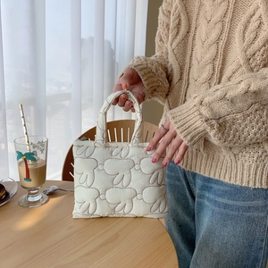 Detailed texture of white quilted tote bag featuring adorable soft rabbit ear design