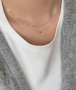 Collares minimalistas de doble capa en plata esterlina dorada usados por una modelo