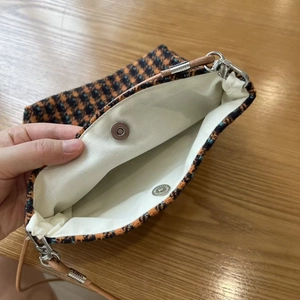 Internal detail of retro houndstooth bag showing canvas lining and magnetic snap closure