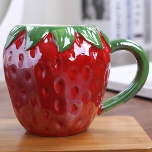 Vibrant strawberry shaped ceramic mug with realistic seeds and green leaf handle decor