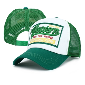 Detail of western embroidery patch on green and white mesh trucker cap with snapback closure
