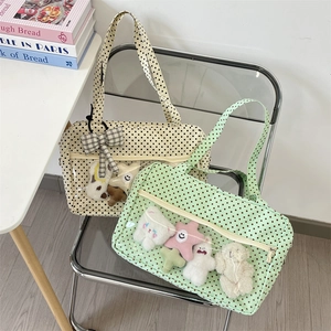 Close-up of polka dot canvas tote bag featuring a transparent PVC window with plush charms