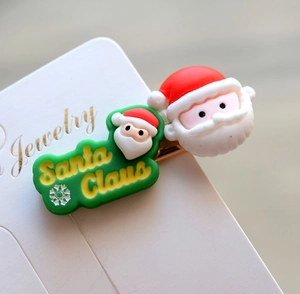 Detail shot of Santa Claus hair clips with festive red and green resin embellishments