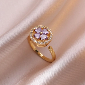 Adjustable golden open ring with purple heart-shaped clover zircon stones and silk backdrop