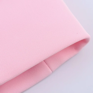 Detail of pink woven fabric texture and high-quality stitching on feather cuff suit