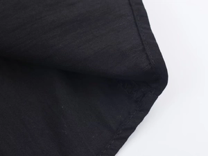 Close-up of black poplin shirt detail showing fine stitching and textured cotton fabric