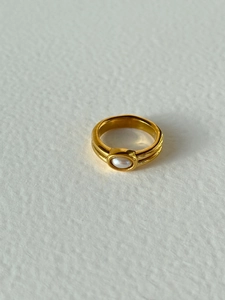 Detail shot of vintage 18k gold plated ring with a central white oval freshwater pearl
