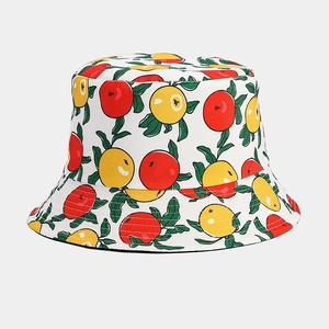 Detail of white cotton bucket hat featuring vibrant red and yellow fruit patterns and leaves