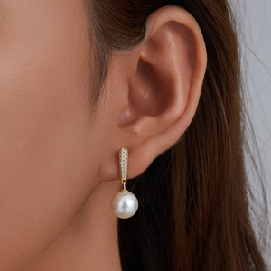Luxe sterling silver pearl drop earrings with sparkling zircon micro-paving worn by a model