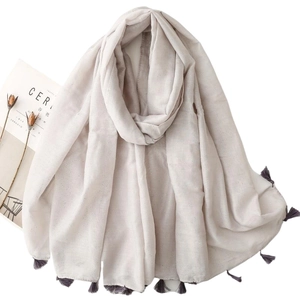 Light gray cotton linen scarf with subtle silver glitter and purple tassels laid flat