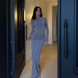 Détail de la robe grise à manches longues avec fronces à la taille et coupe moulante