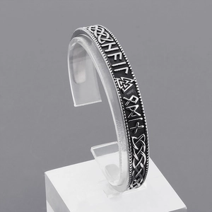 Detail of vintage silver Viking runes and Celtic knot patterns on a steel cuff bracelet