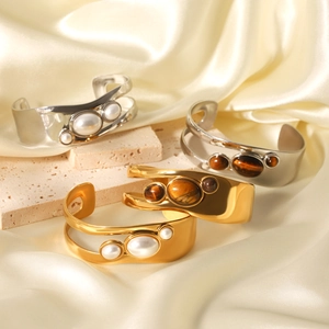 Cut-out open bangle with tiger eye and pearl in gold and silver stainless steel finish