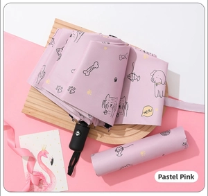 Detail of automatic pink folding umbrella with cartoon puppy patterns on a tray