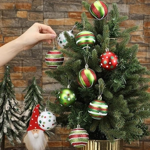 Detail of red and green glittery Christmas ornaments hanging on a festive pine tree