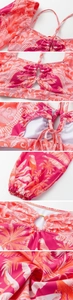 Detail of tropical print bikini with parrot motifs, metal ring, and lace-up straps
